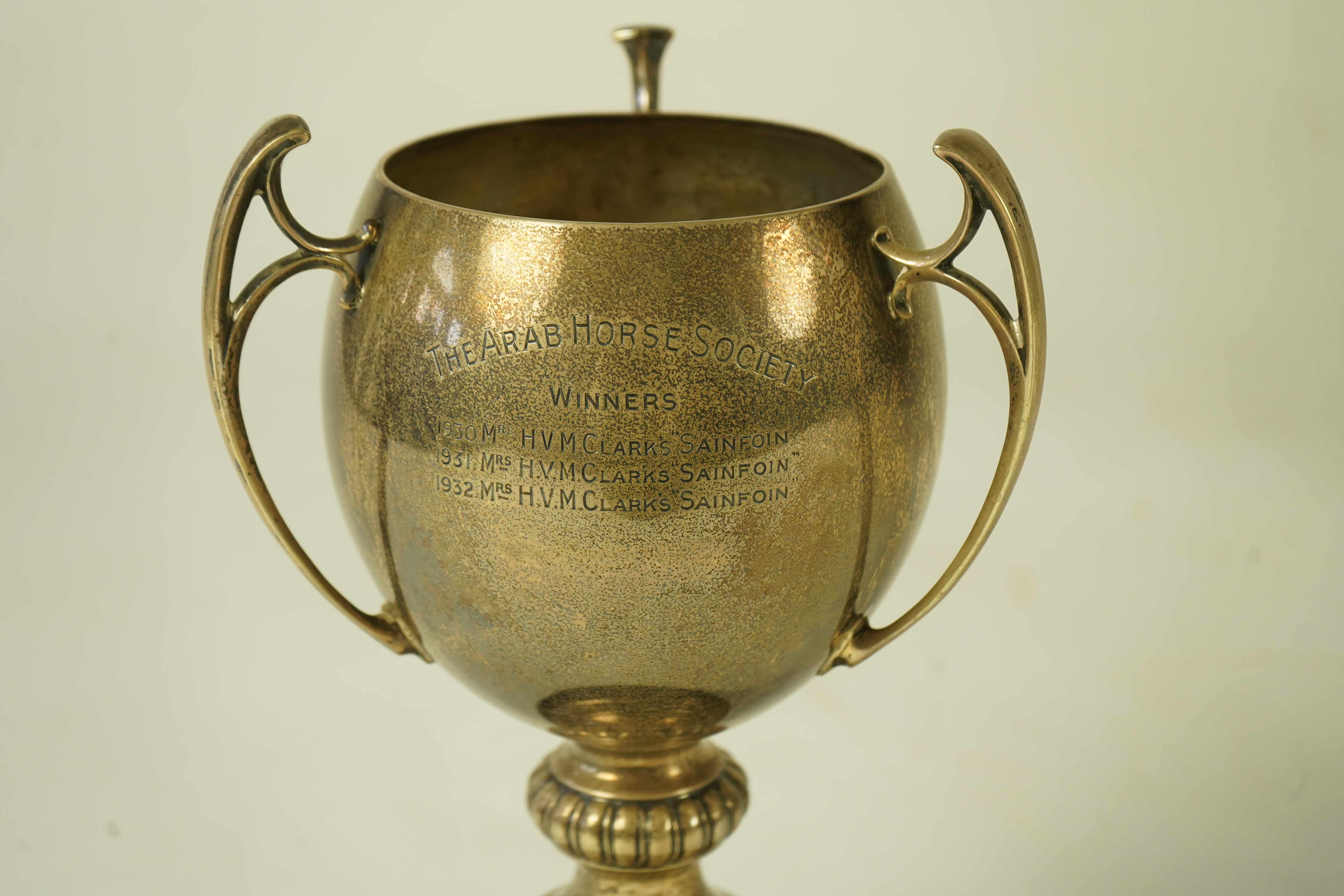 A George V silver tri-handled presentation pedestal trophy cup, with engraved horse racing inscription relating to 'The Arab Horse Society Challenge Cup for the Best Stallion or Colt'